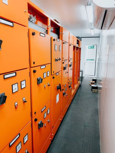 Line-up of orange industrial electrical panels in a plant room