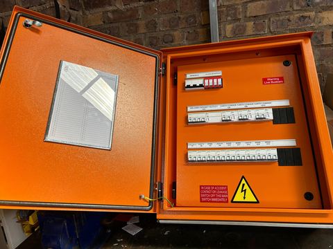 Open orange distribution board with circuit breakers