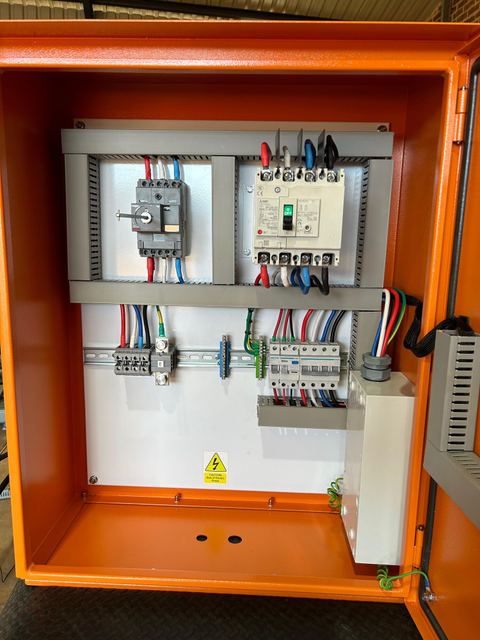 Open orange enclosure with contactors, breakers and wiring